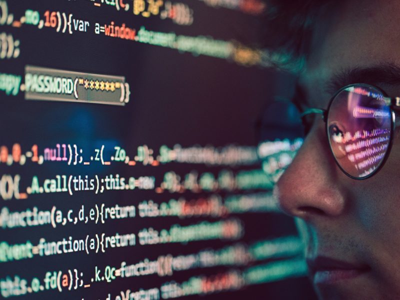 Hacker using computer, smartphone and coding to steal password and private data. Screen with code